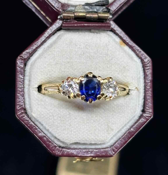 Vintage 1950s three‑stone ring with 0.50ct oval royal blue sapphire flanked by two 0.40ct G VS round brilliant diamonds set in 18ct yellow gold.