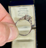  Close-up of a vintage Art Deco engagement ring detailing the brilliant cut diamond and intricate platinum setting from the 1920s.