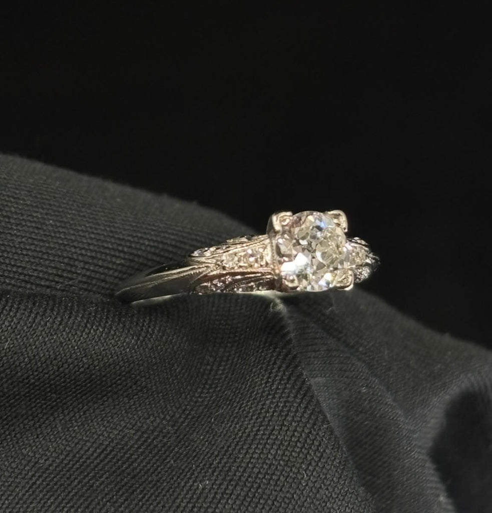 Vintage Art Deco engagement ring in platinum featuring a 0.46ct semi‑modern cut centre diamond and single‑cut pavé stones.