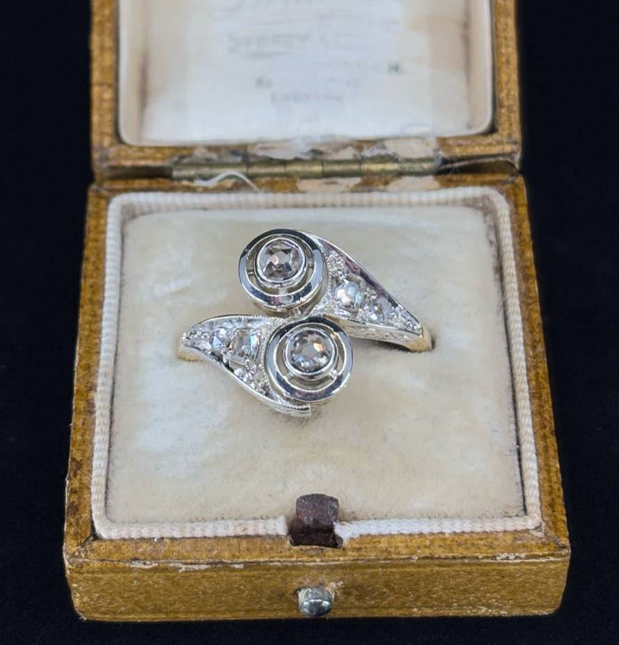 Vintage Edwardian ring featuring bezel set diamonds and engraved shoulders.