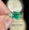Vintage Art Deco emerald-cut emerald ring, medium green 1.25ct stone flanked by shield and baguette diamonds.