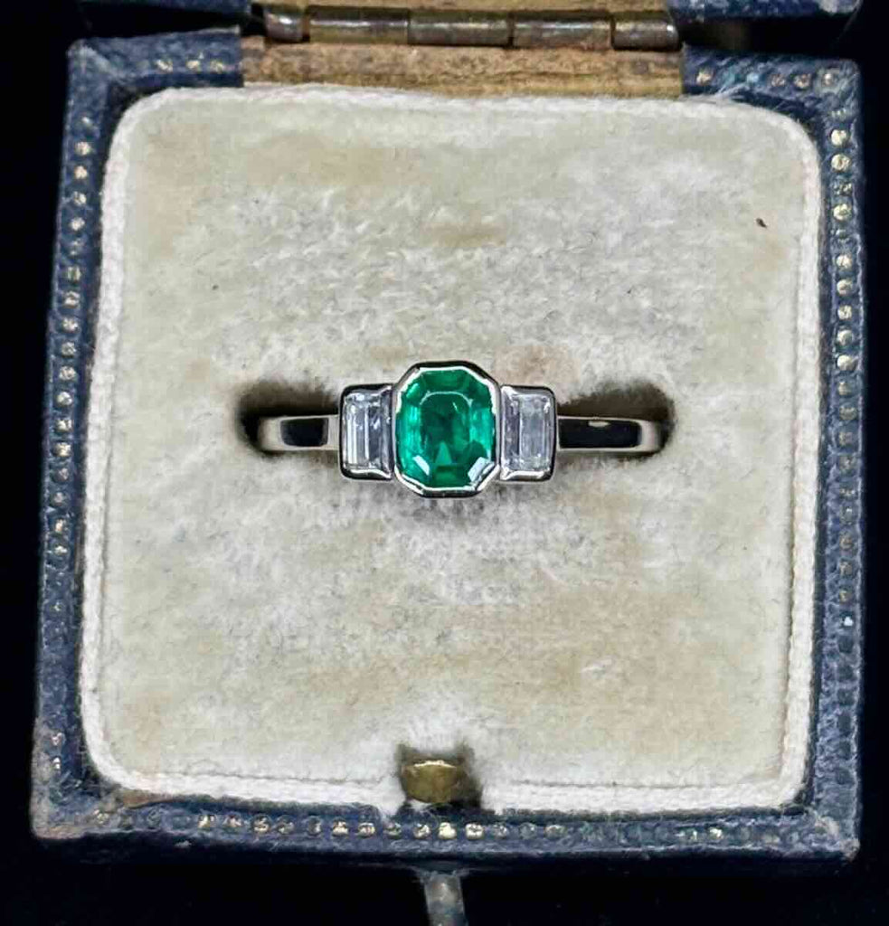 Collector quality vintage emerald ring with very good green Colombian emerald flanked by G/VS baguette diamonds, showcasing bespoke mid-century craftsmanship.