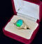 Detailed view of the oval black opal displaying bright green flashes of color against a gold setting.