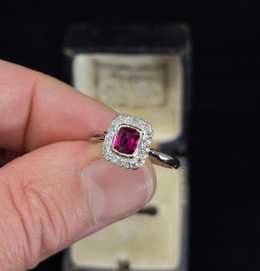 Vintage ruby and diamond cluster ring from the 1920s, set in platinum with an 18ct white gold band, showcasing a rich red ruby.