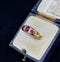 Vintage Victorian ruby and diamond half hoop ring worn on a hand, highlighting its elegant design and vibrant gemstones.